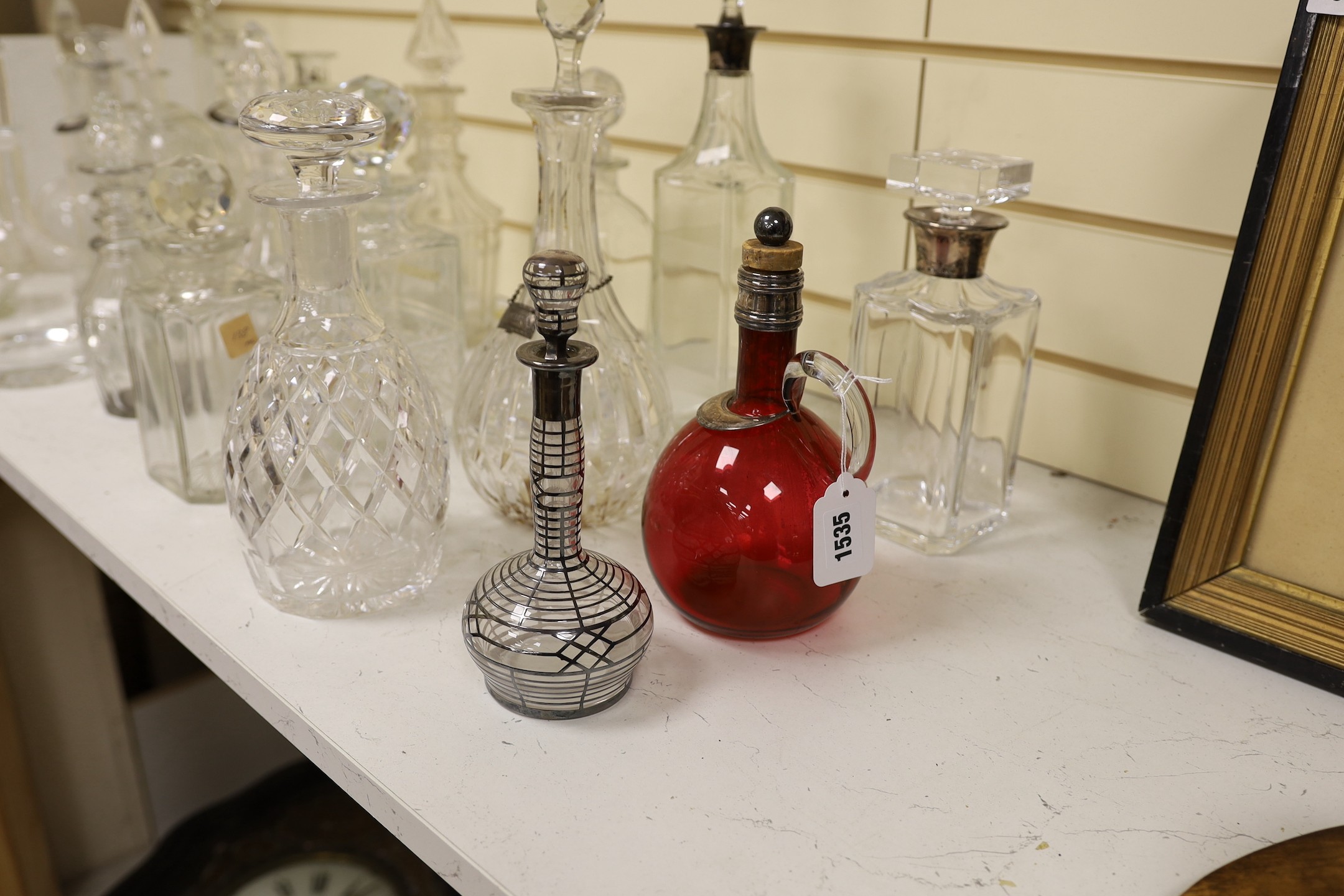 A quantity of various glass decanters, some silver mounted
